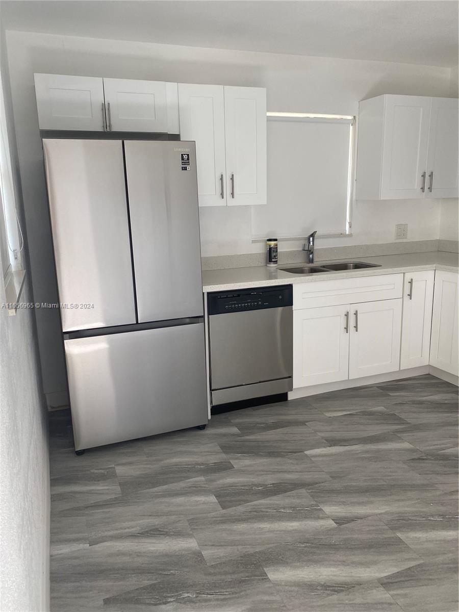 a kitchen with a refrigerator and a sink