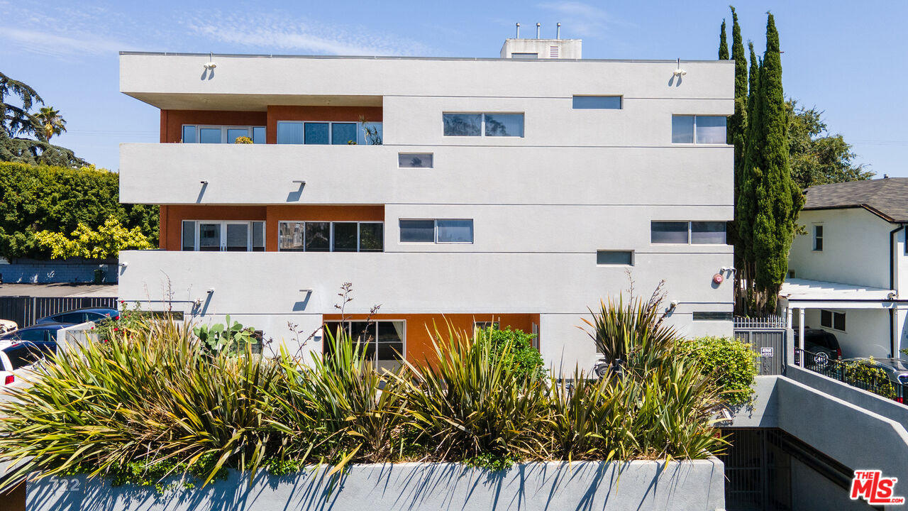 a view of a building with a yard and potted plants