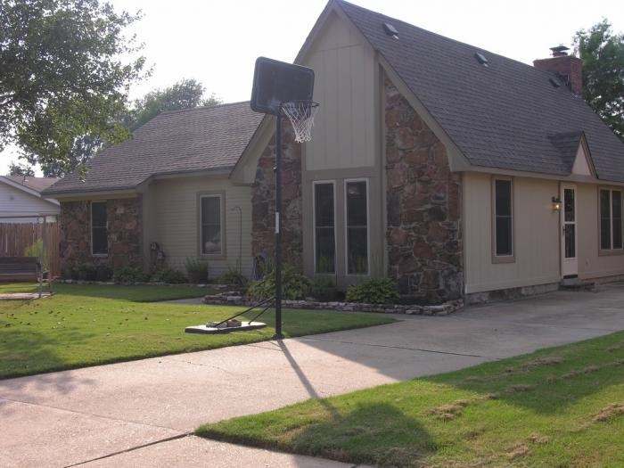 a brick house with a yard and large tree