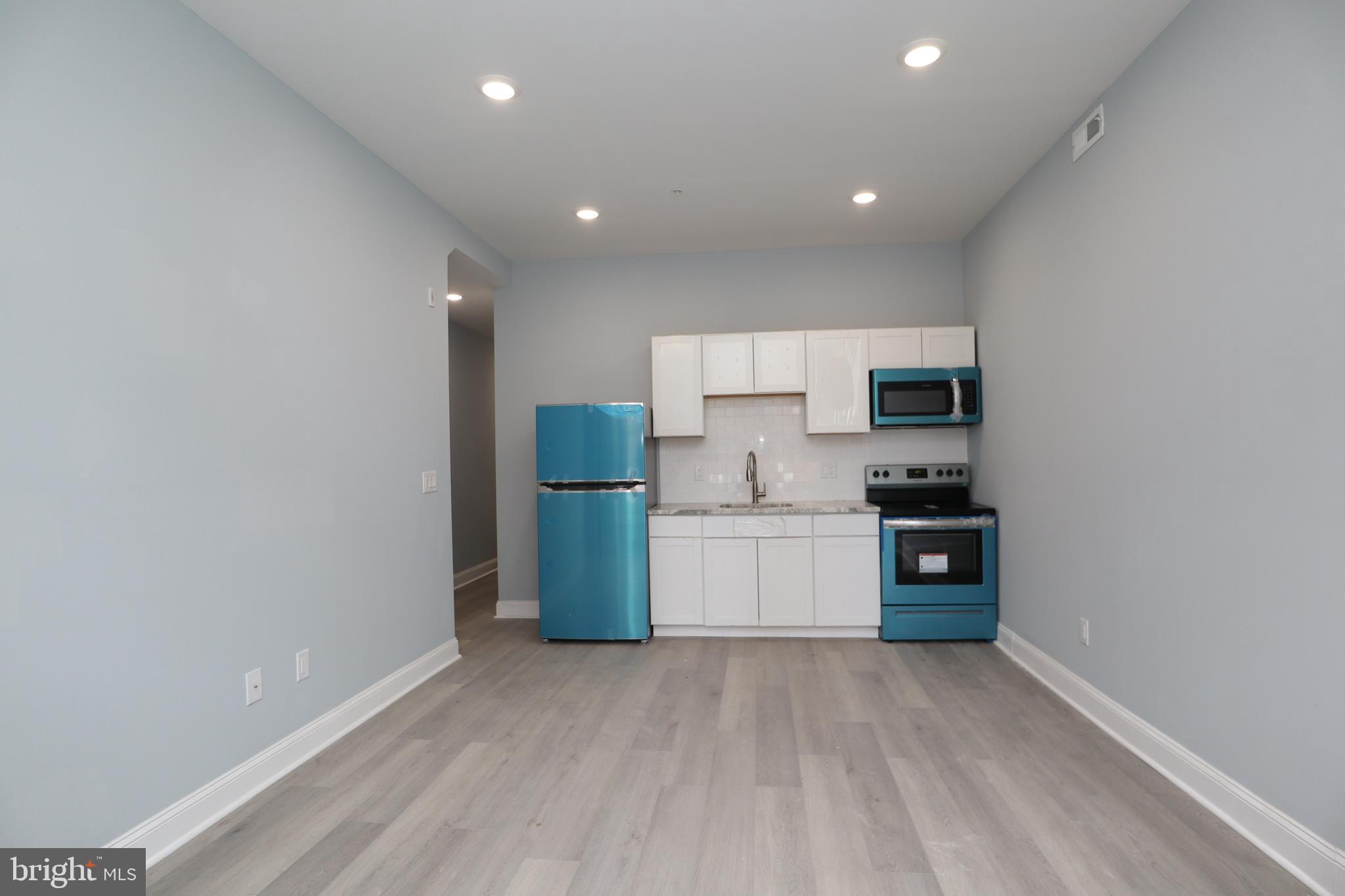 a kitchen with a refrigerator and a stove top oven