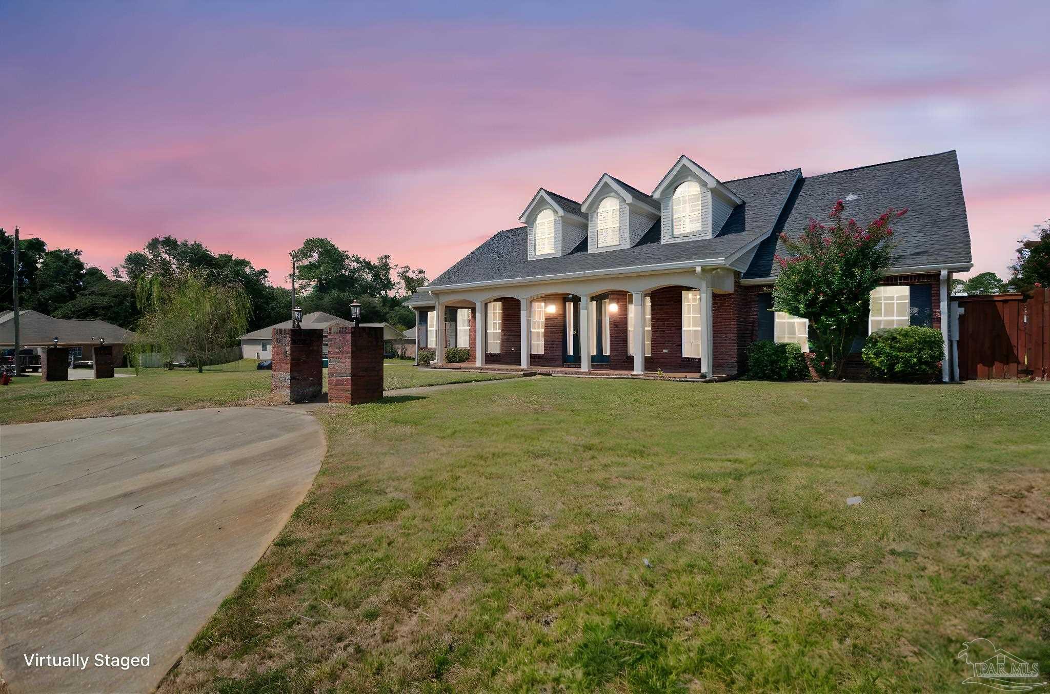 a front view of a house with a garden and yard