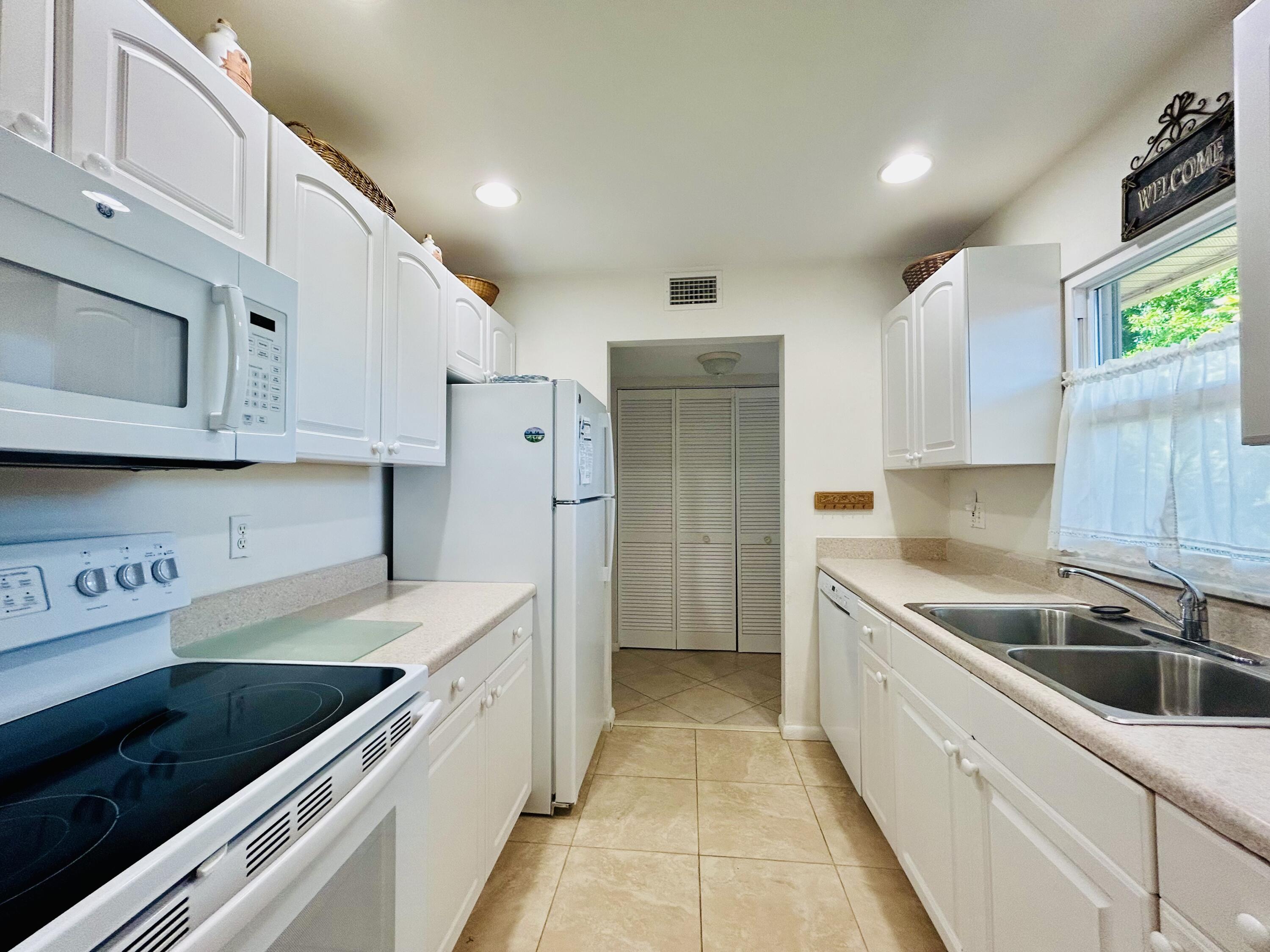 a kitchen with stainless steel appliances granite countertop a sink and a refrigerator