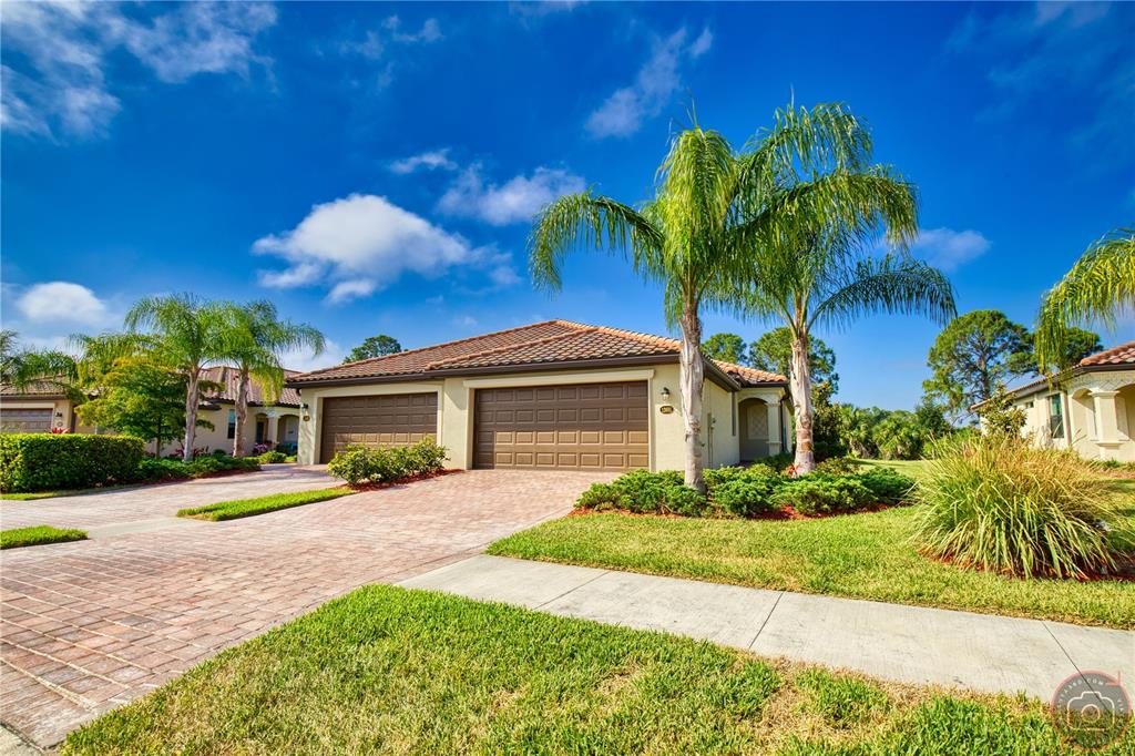 a view of a house with a yard and palm trees