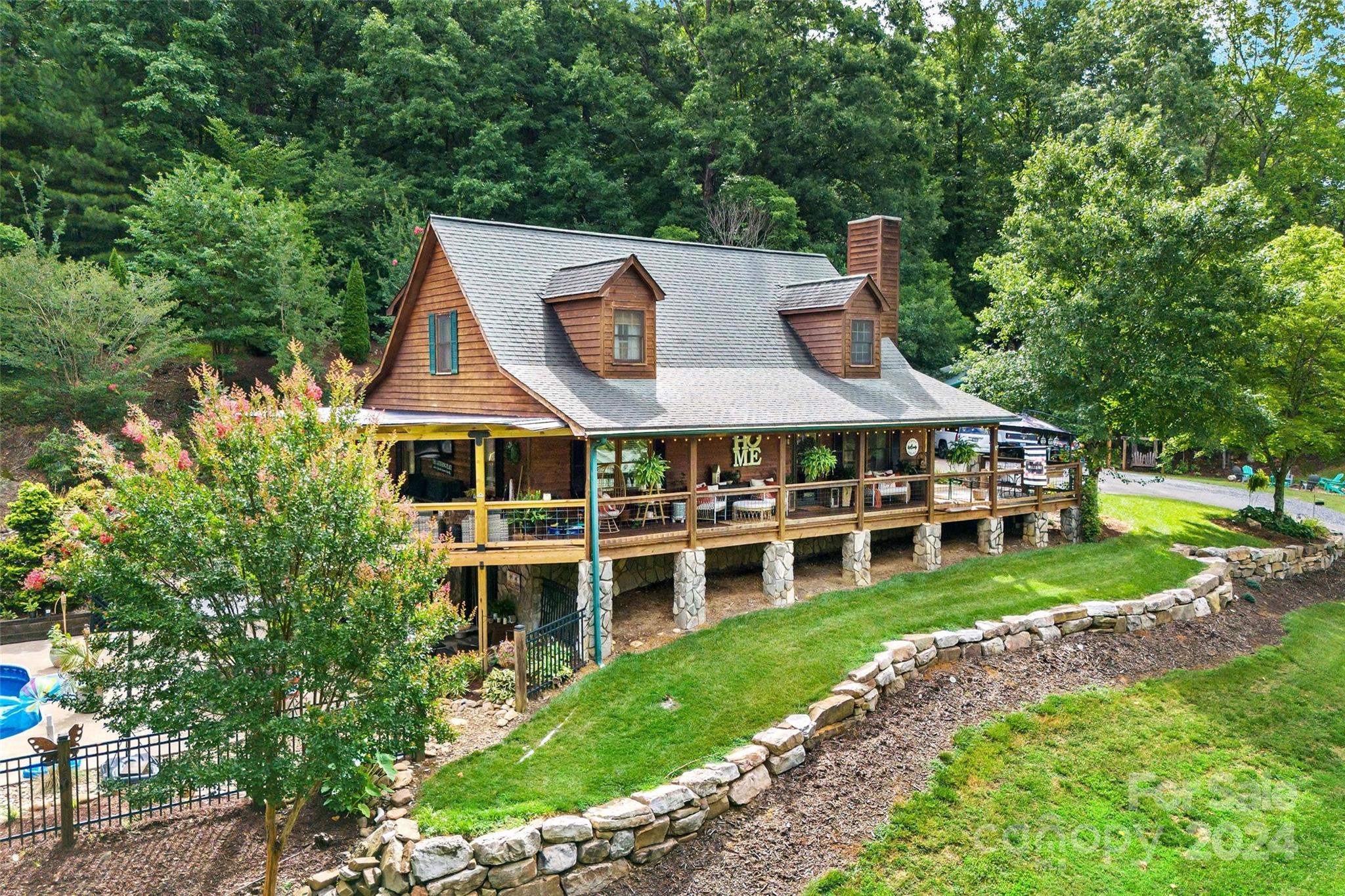 a view of a house with a big yard and large trees