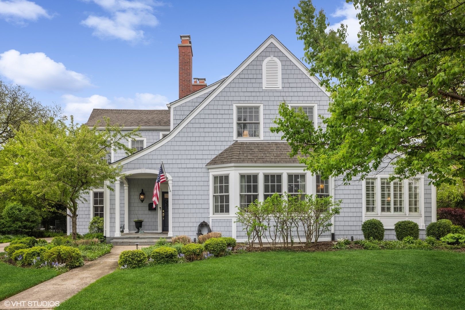 a front view of a house with a garden and plants