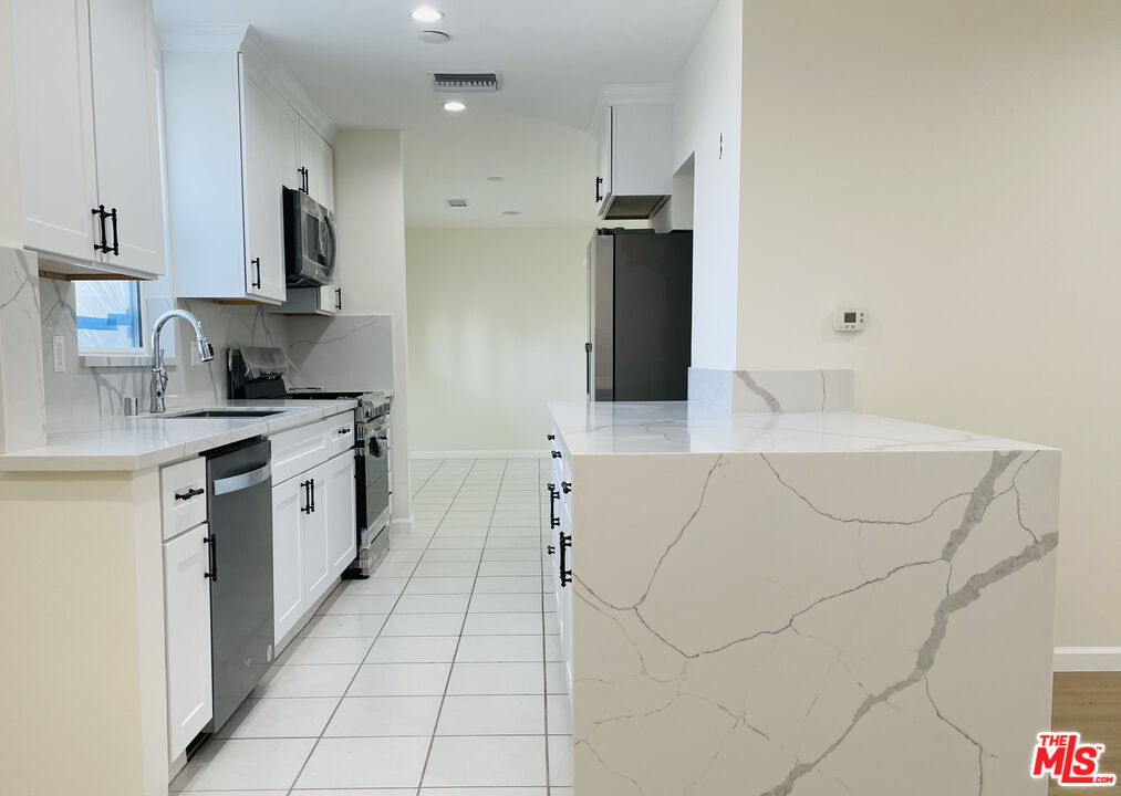 a kitchen with stainless steel appliances white cabinets and a sink