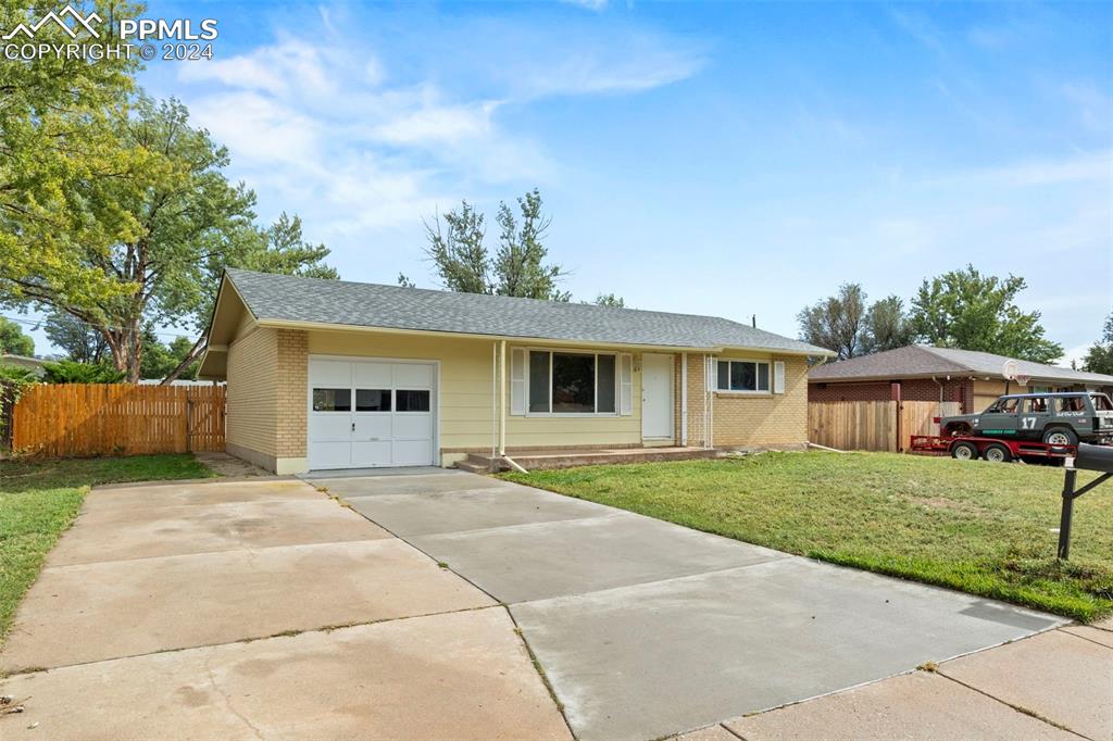 Ranch-style home with a garage and a front lawn