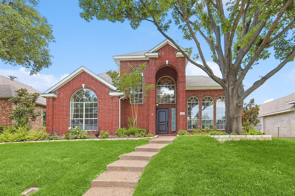 a front view of a house with a garden and yard