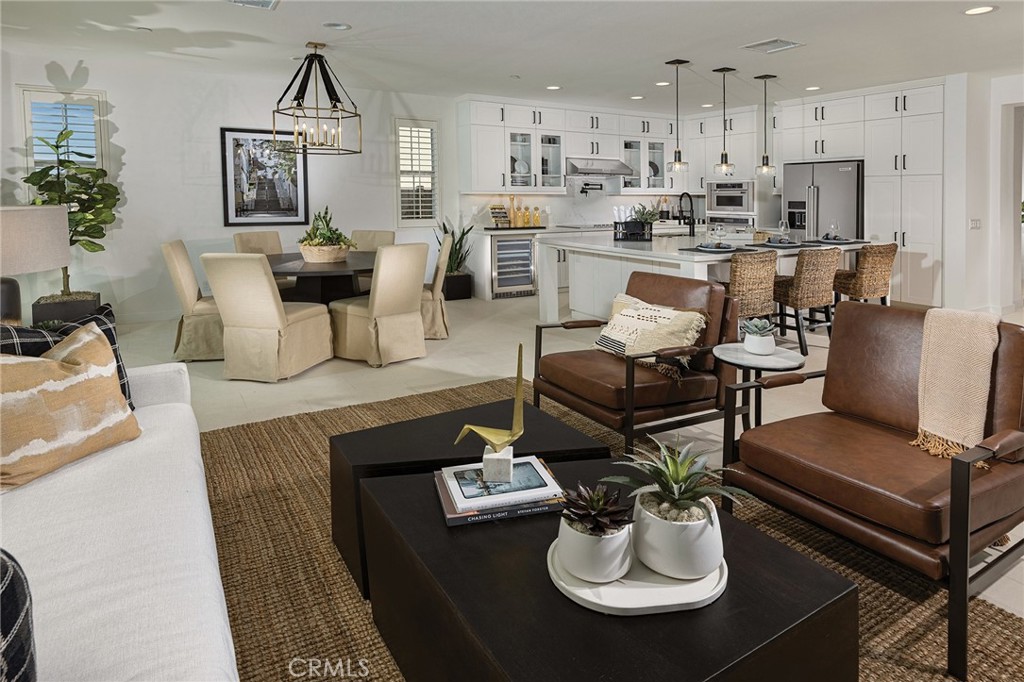 a living room with furniture kitchen view and wood floor