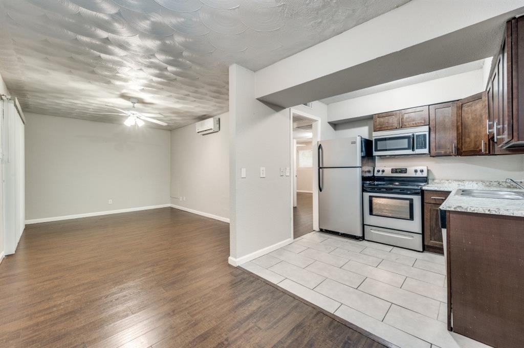 a kitchen with granite countertop a refrigerator and a stove top oven