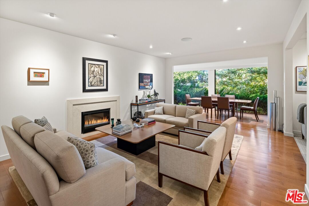 a living room with furniture fireplace and a large window