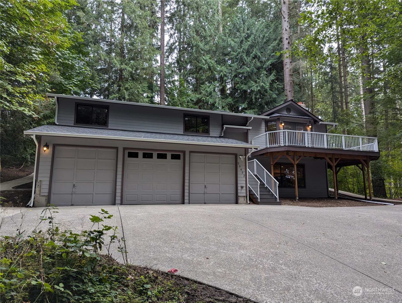 a front view of a house with glass windows and garage