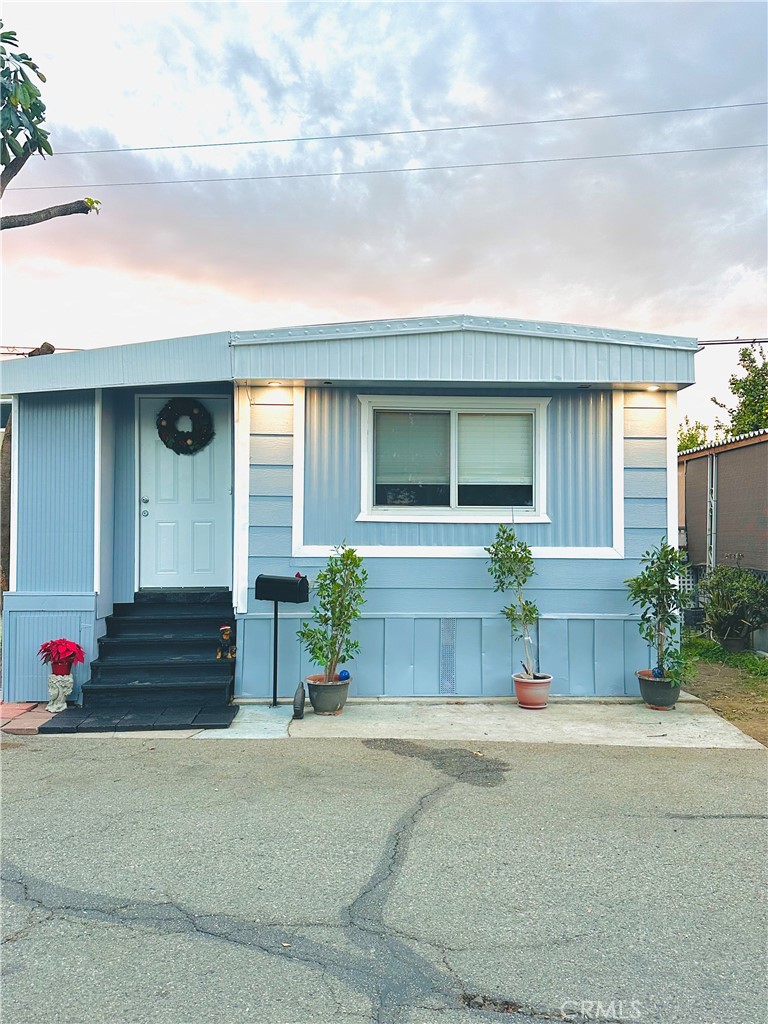 a front view of a house with a yard and potted plants