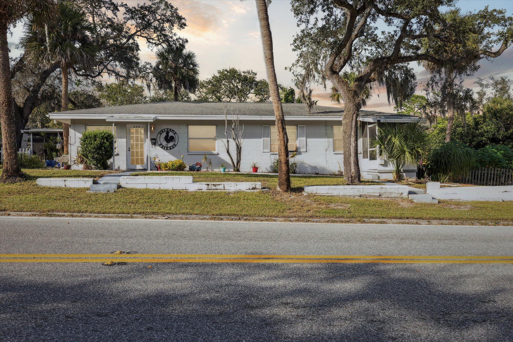 a view of a house with a swimming pool and a lawn chairs under an umbrella