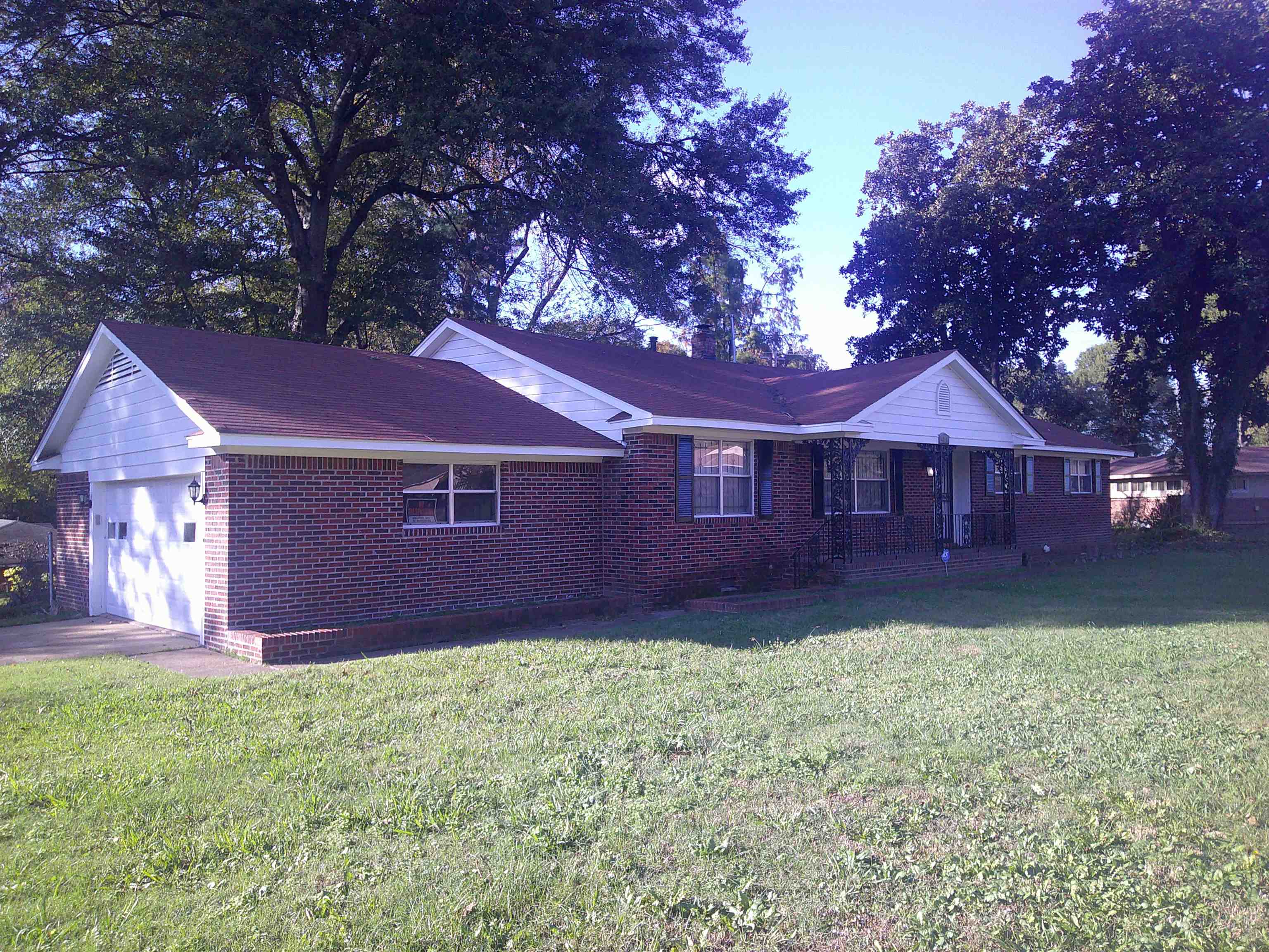 a view of a yard in front of a house with large trees