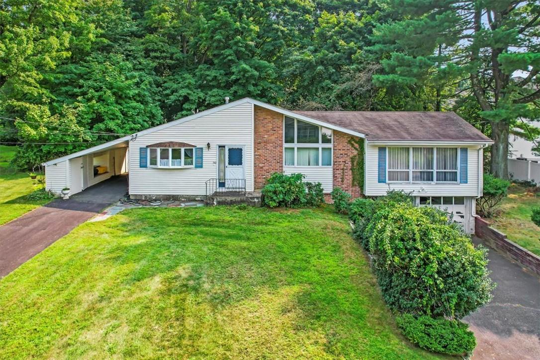 Single story home featuring a carport and a front yard