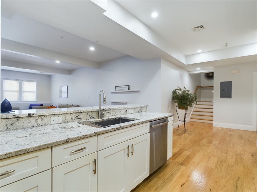 a kitchen with sink and view of living room