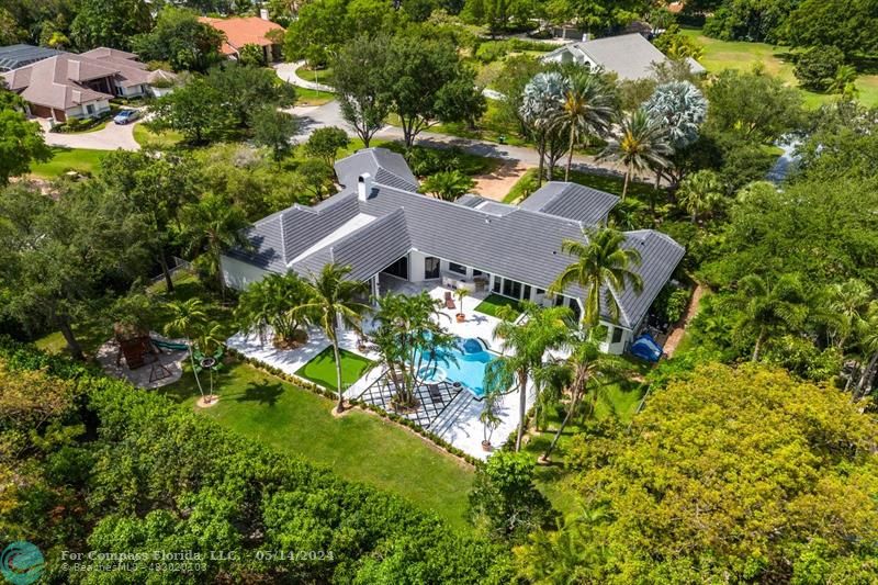 an aerial view of residential houses with outdoor space and trees all around