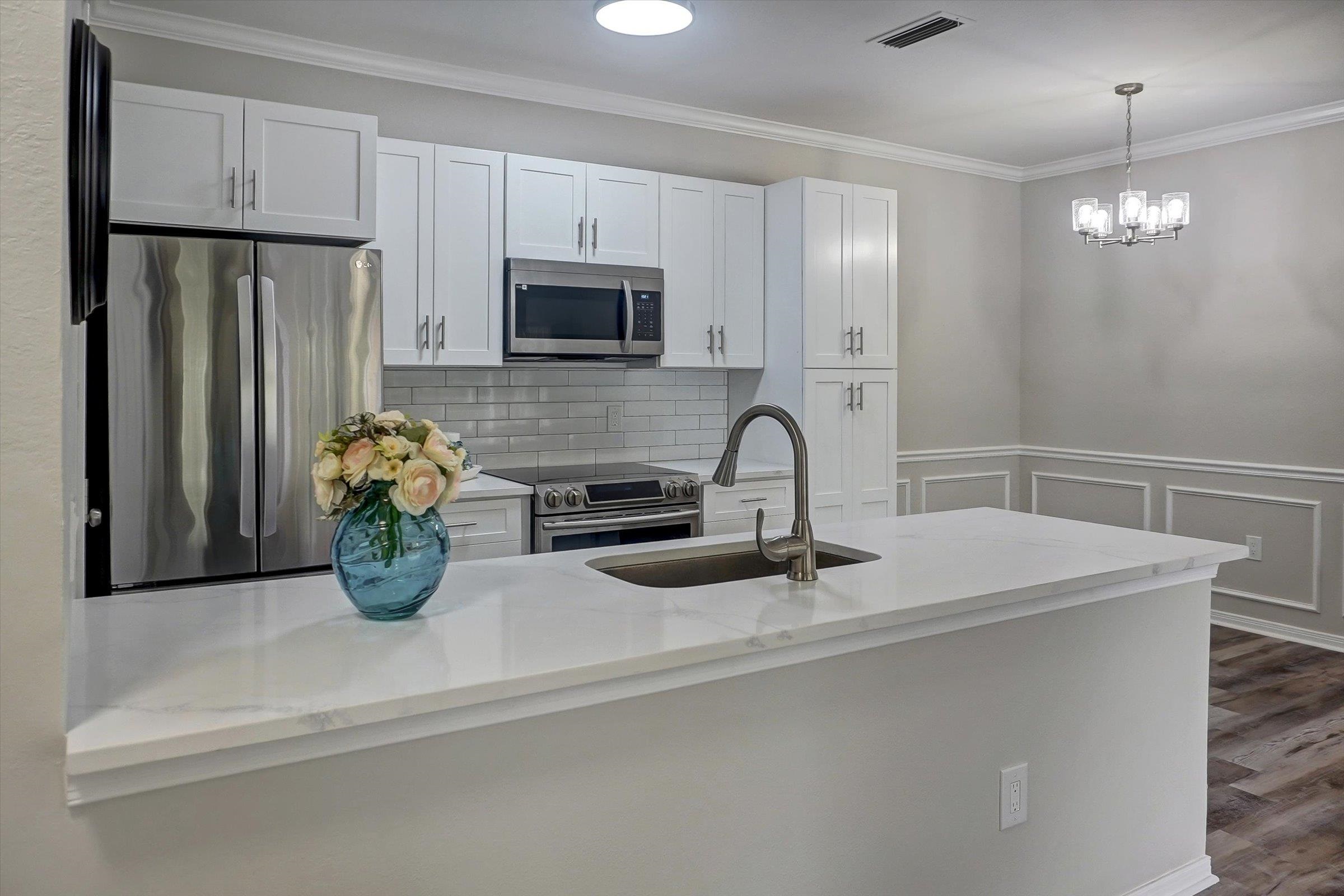 a kitchen with stainless steel appliances granite countertop a sink a refrigerator and a granite counter tops