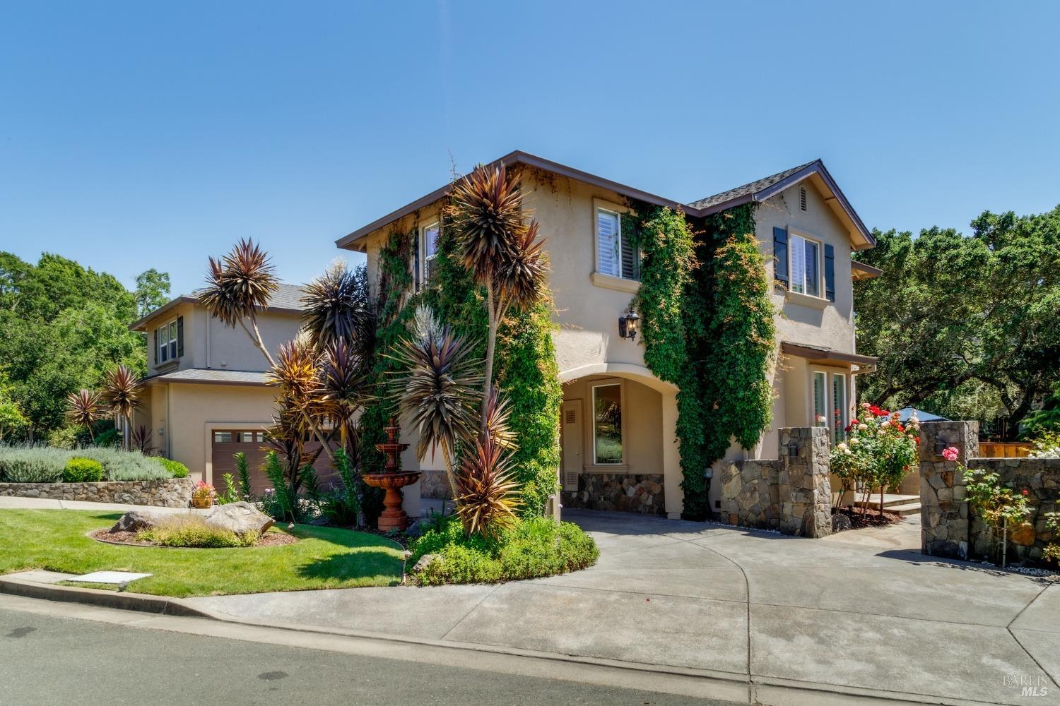 a front view of a house with a yard and potted plants