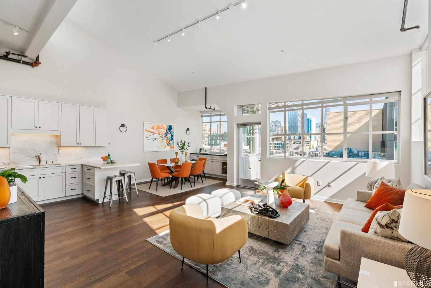 Voluminous and airy great room with soaring ceilings, newly refinished hardwood floors and walls of steel paned windows with downtown views and custom electric solar shades.