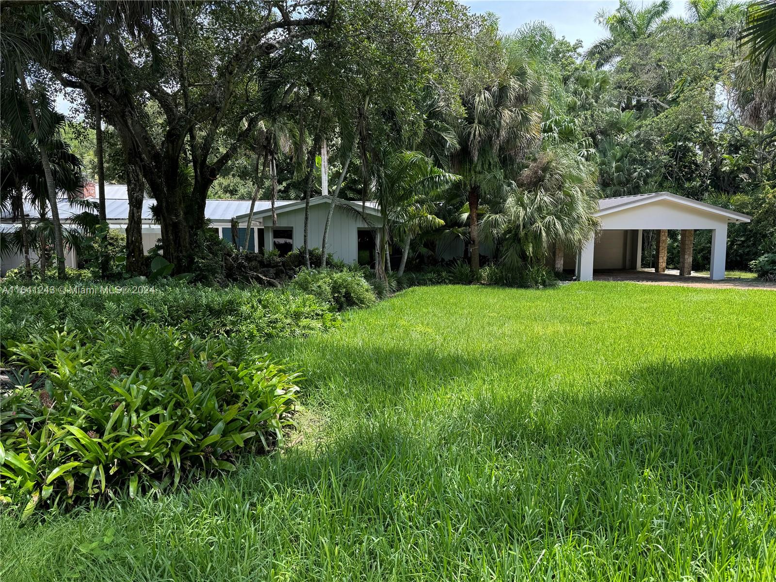 a front view of a house with a yard and trees