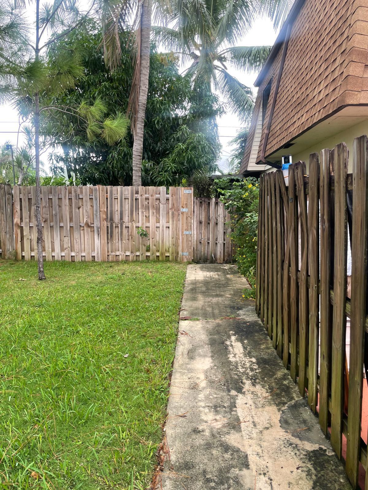 a view of a backyard with wooden fence