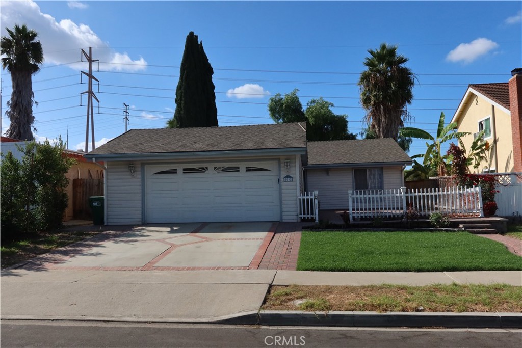 a front view of a house with a garden and yard