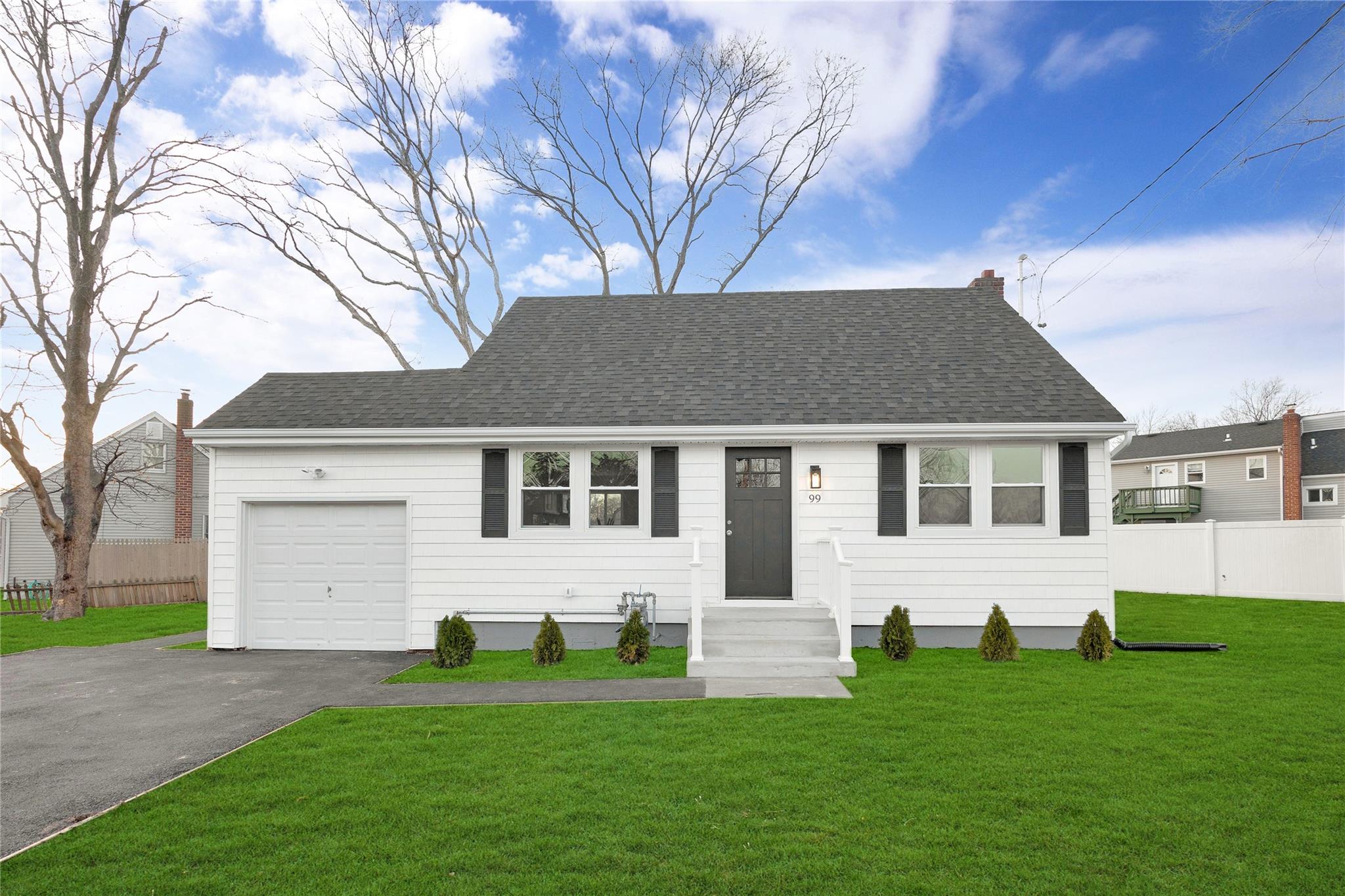 View of front facade with a garage and a front lawn