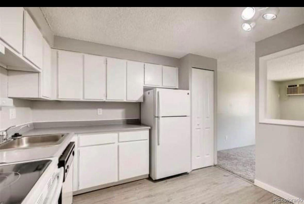 a kitchen with a sink a refrigerator and cabinets