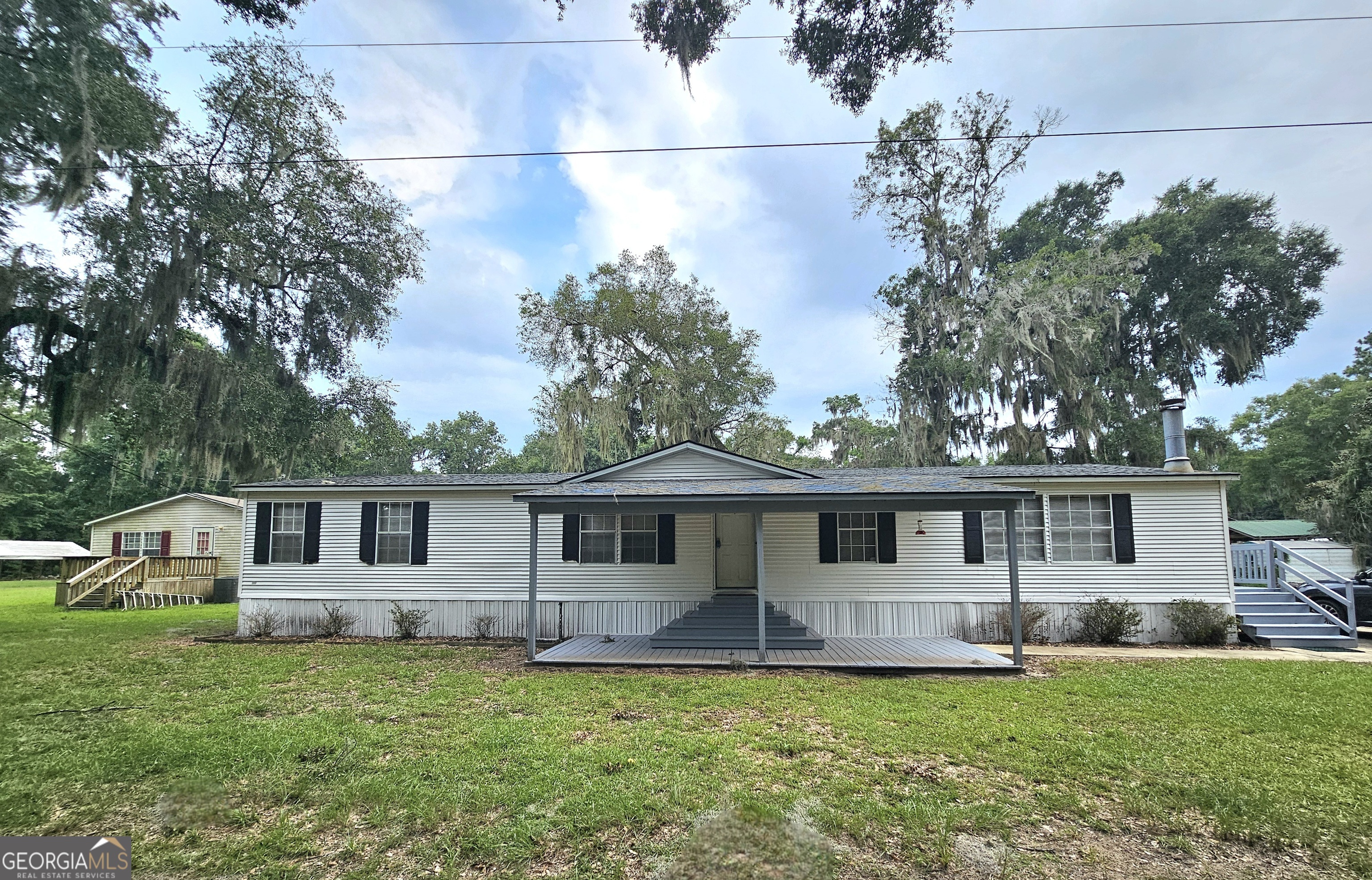 a front view of a house with a garden and deck