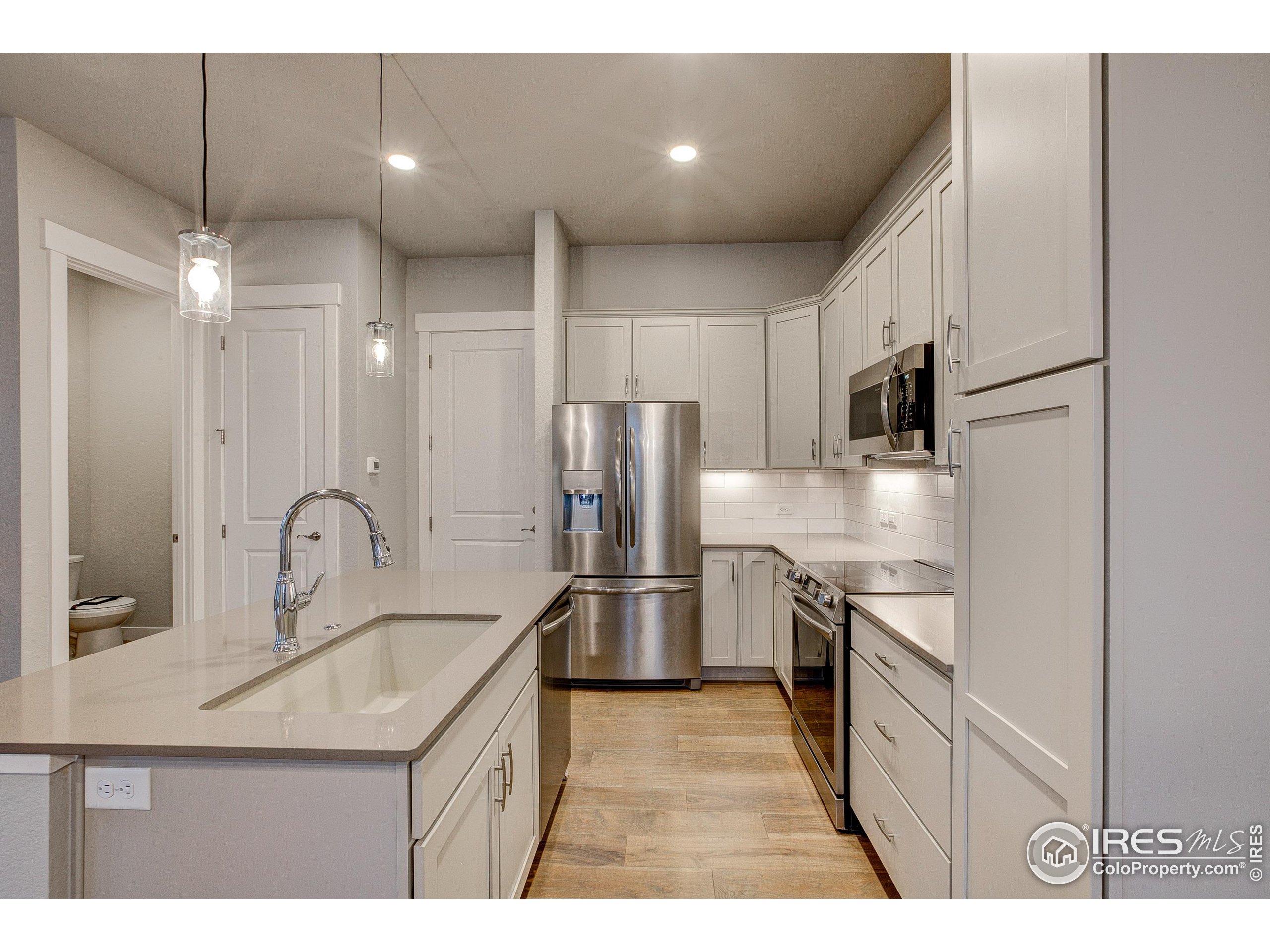 a kitchen with kitchen island granite countertop a sink stainless steel appliances and cabinets