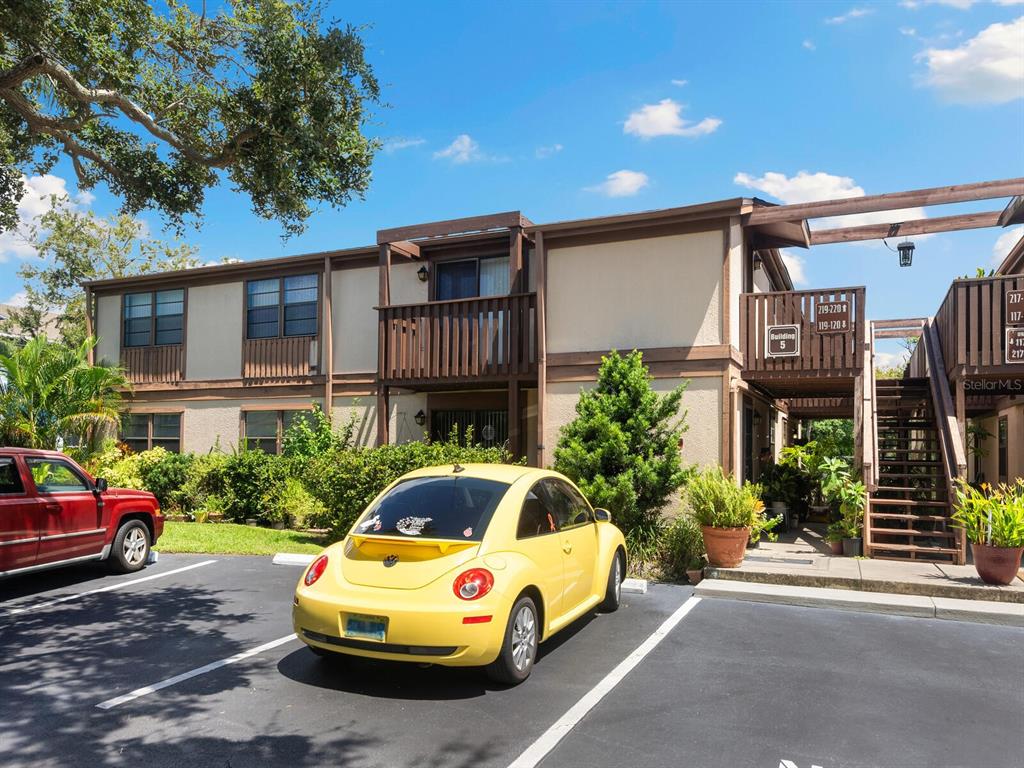 a front view of a house with a garden and parking