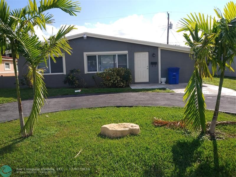 a view of a house with backyard and a tree