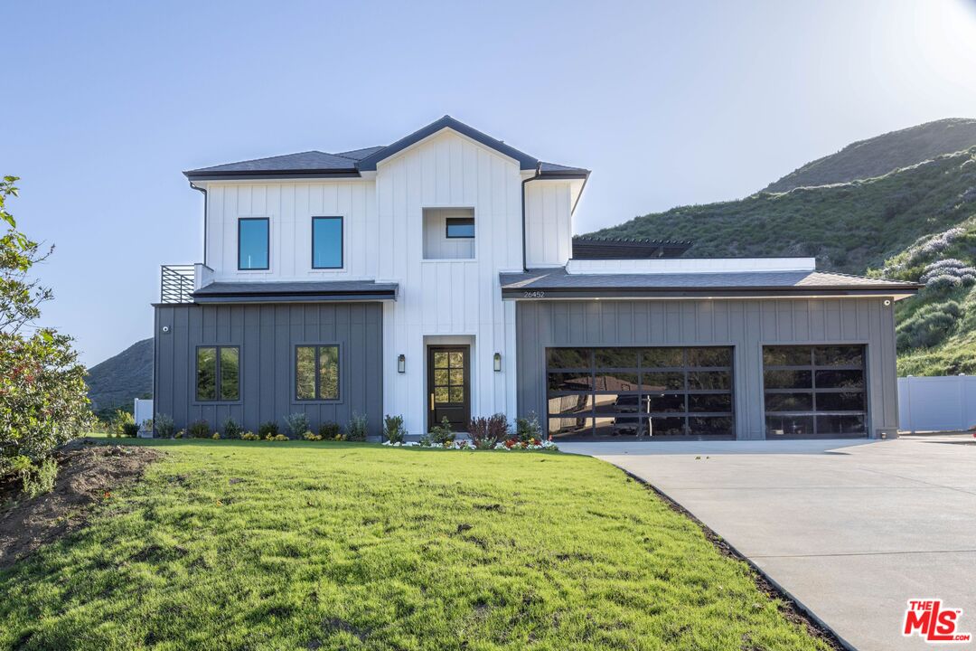 a view of a house with a yard and a garage