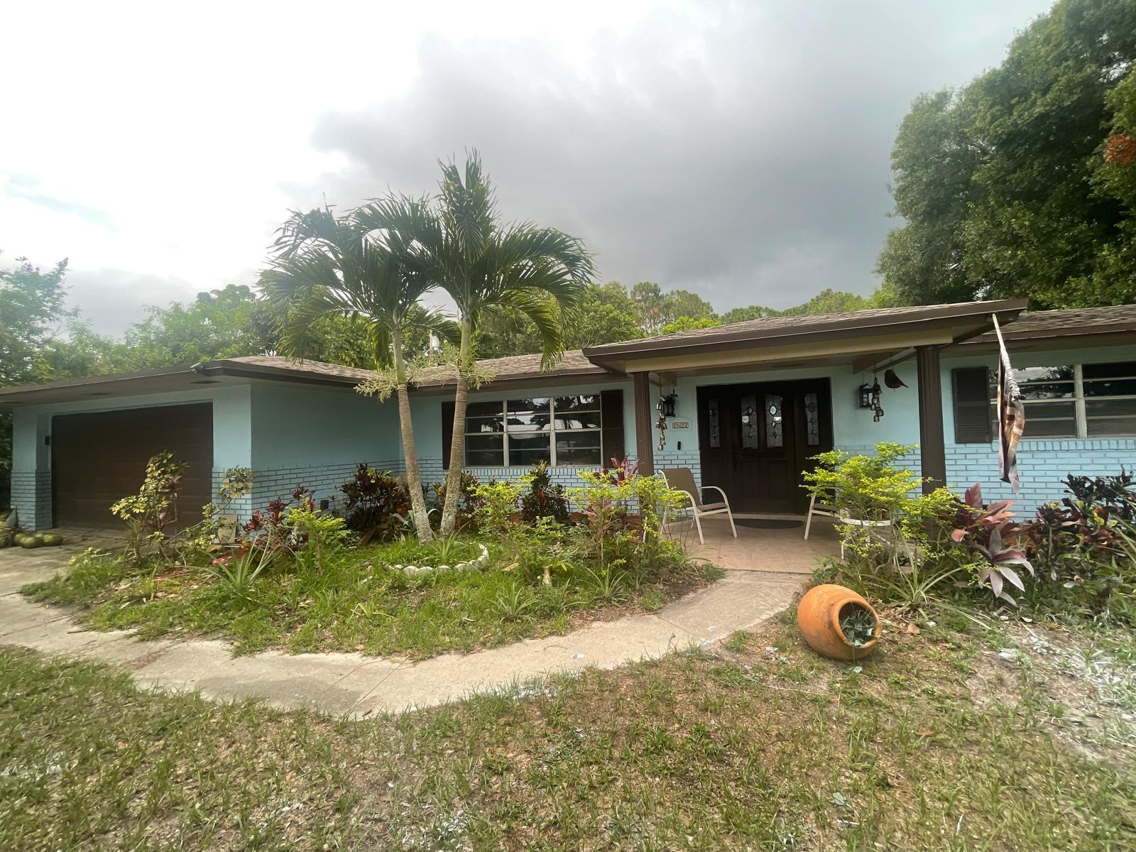 front view of house with a yard and potted plants