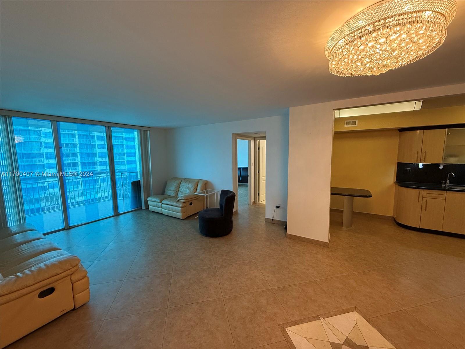 a view of an empty room with furniture and a window