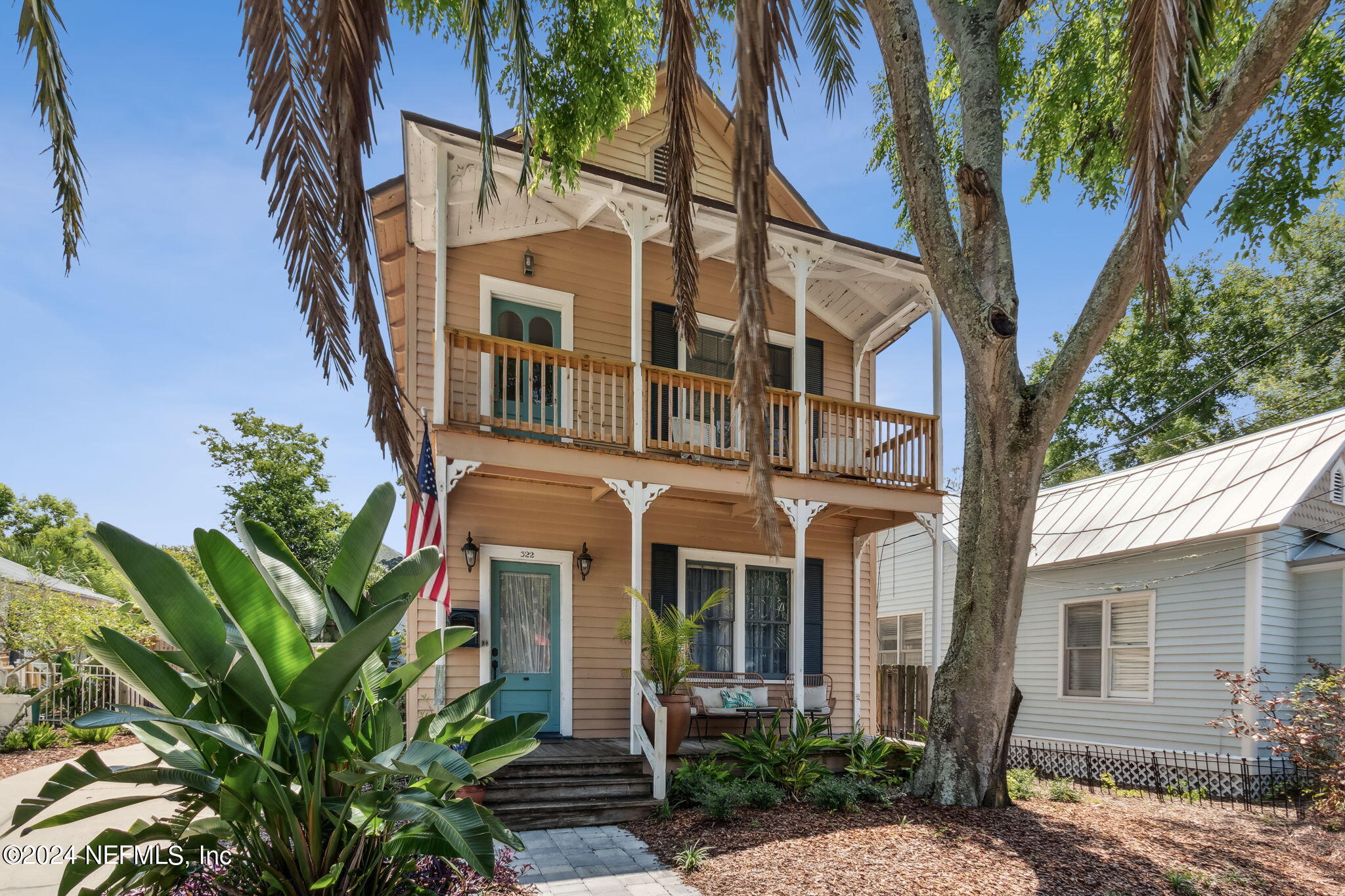 a front view of a house with a tree