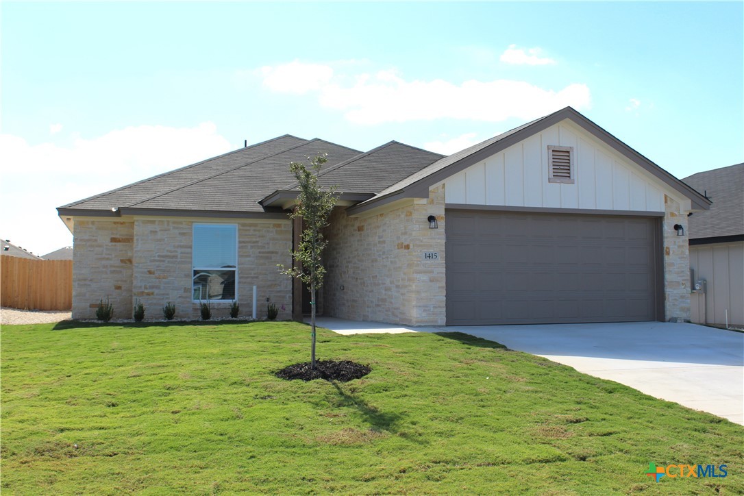 a front view of house with yard and garage