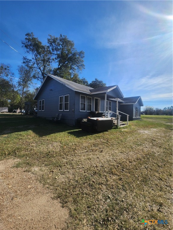 a view of a house with a yard and a large tree