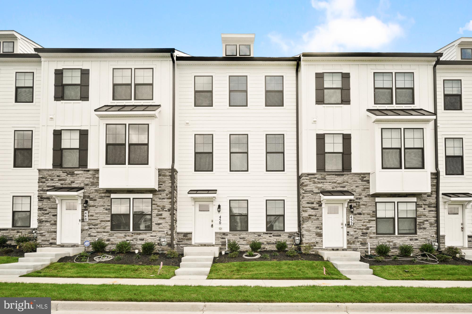 a front view of a residential apartment building with a yard