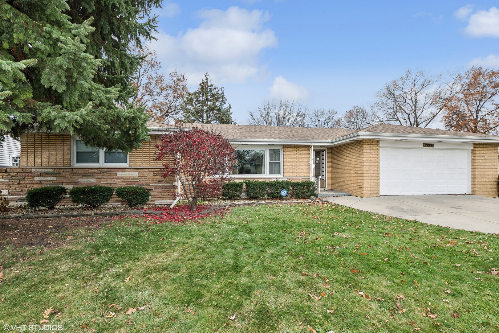 a front view of house with yard and trees around