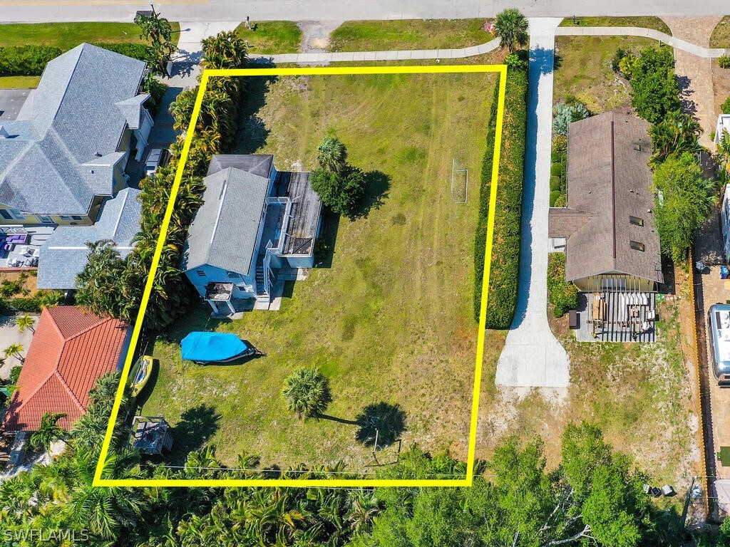 an aerial view of a house with swimming pool and large trees