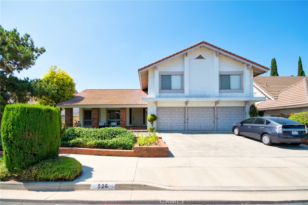 a front view of house with yard and trees in the background