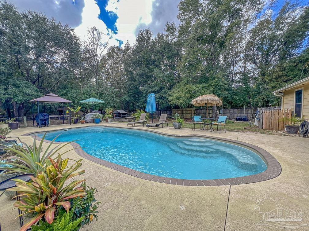 a swimming pool with outdoor seating yard and barbeque oven