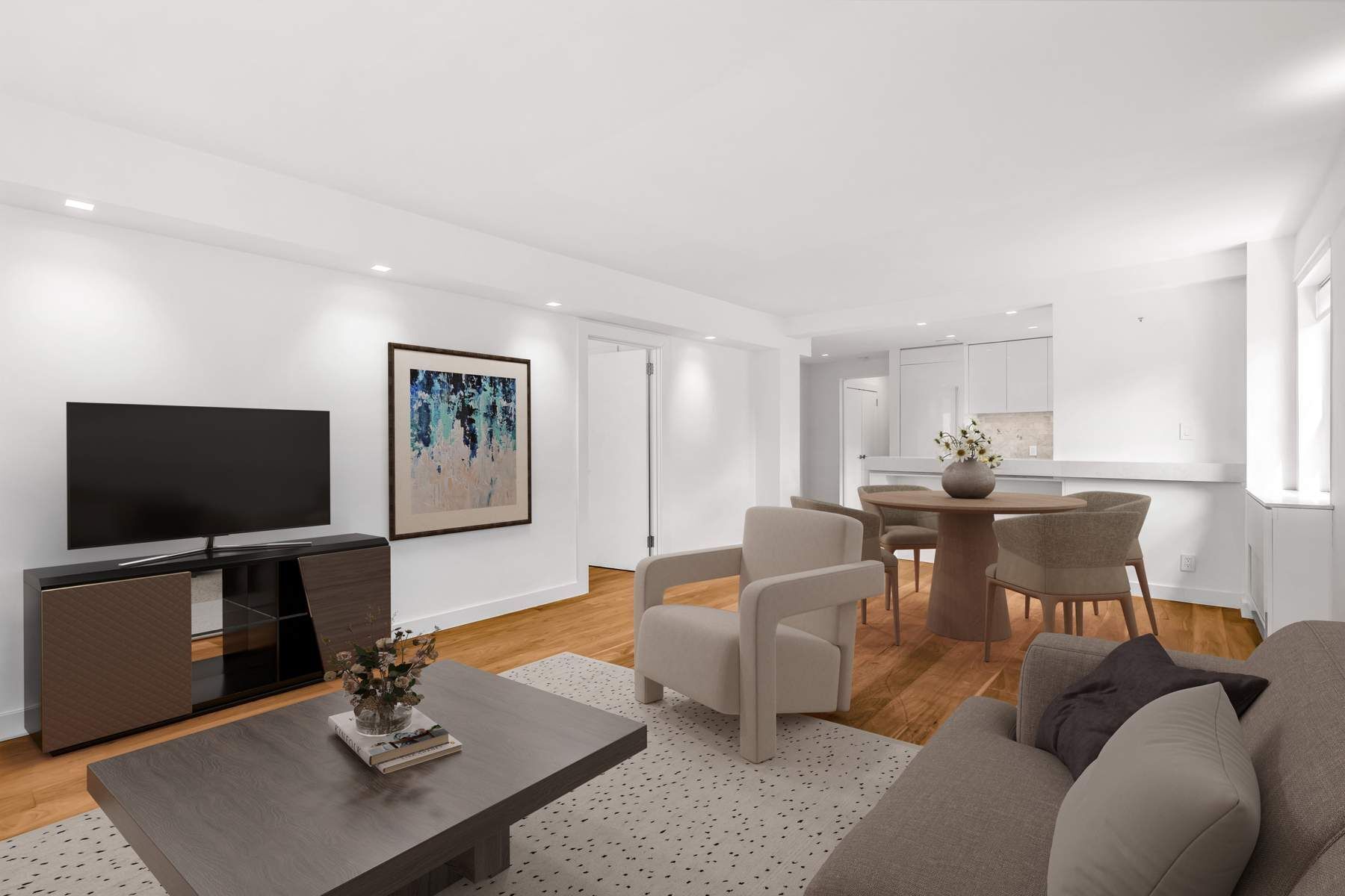 a living room with furniture a flat screen tv and kitchen view