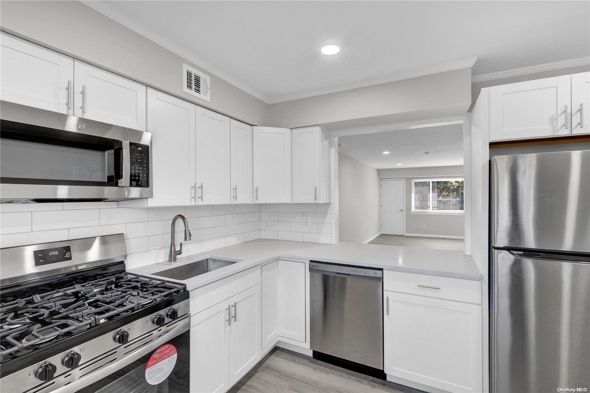 a kitchen with white cabinets and stainless steel appliances