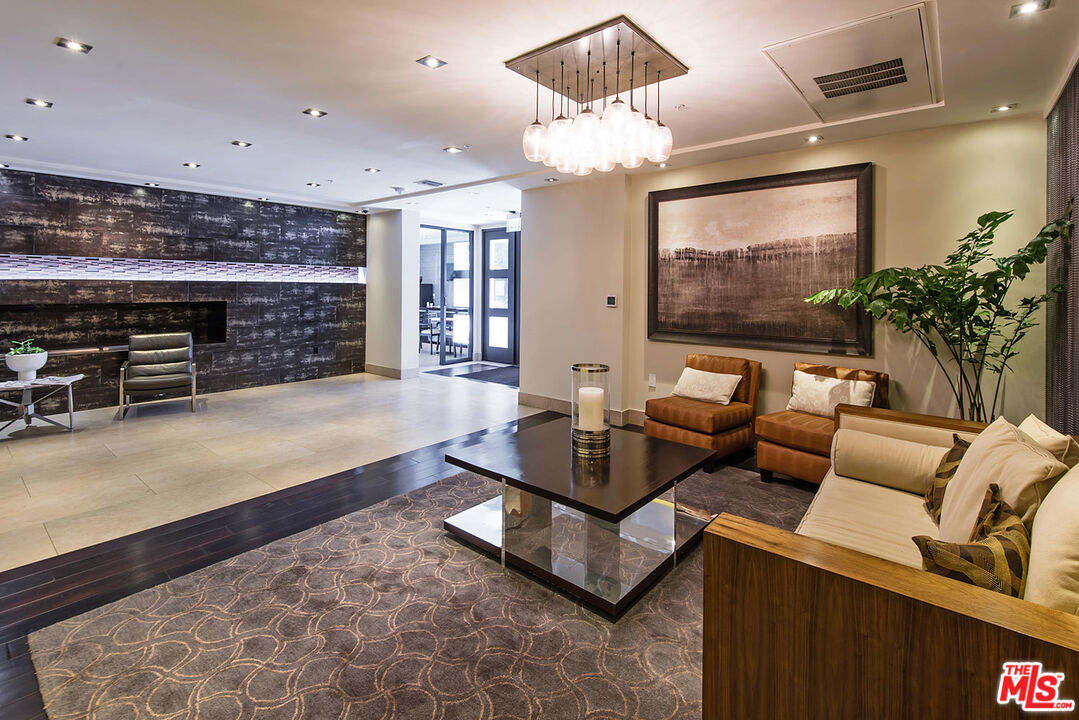 a living room with furniture a chandelier and a flat screen tv