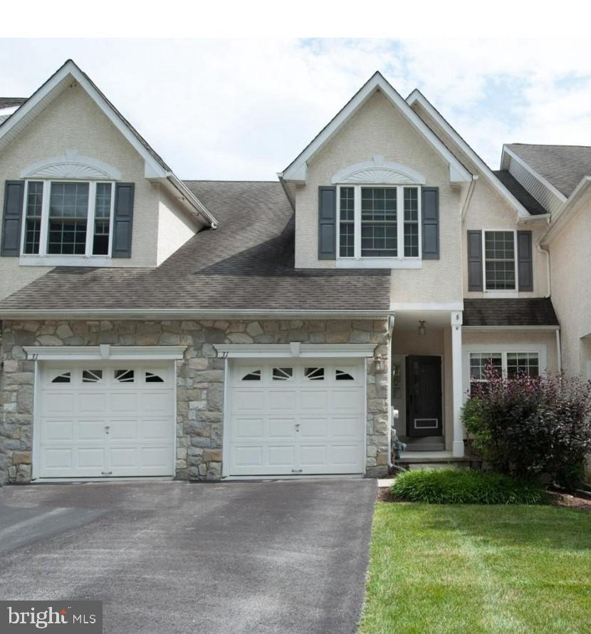 a front view of a house with a garden and garage