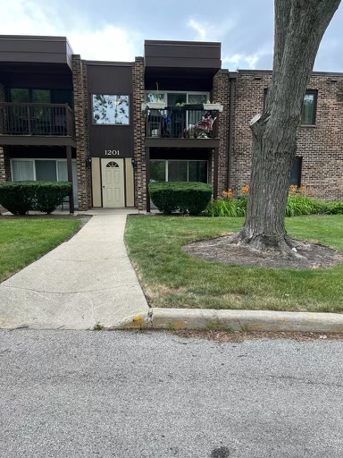 front view of house with a yard and potted plants